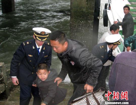 孤島學生坐“水上校車”開學 海巡艇護航 圖為海事執法人員護送上學的小學生。 陳小芬 攝