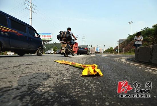 長沙生態動物園附近五車相撞 有四輛黃色校車 地上殘留著校車玻璃碎片,有塊塑料布上寫著“請停車等候”的字。圖/滾動新聞記者