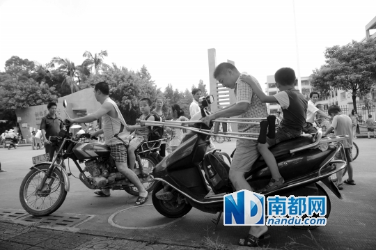 <p>因校車座位不夠，洪梅第二小學今年的新莞人新生不能坐校車，許多家長只能騎車接送孩子。南都記者劉在富攝<br /><br /></p>