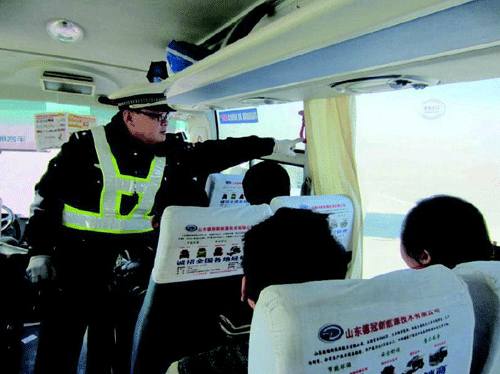執(zhí)勤交警現(xiàn)場檢查客運車輛安全設施