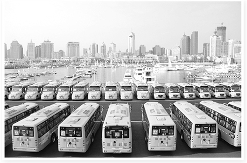 整齊停放在青島市奧帆中心的交運溫馨校車。
