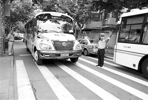 “長(zhǎng)鼻子”校車緩緩駛近愛菊小學(xué)。 本報(bào)記者 葉辰亮攝